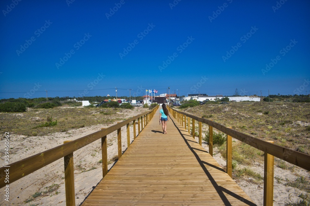 woman walking on a boardwalk
