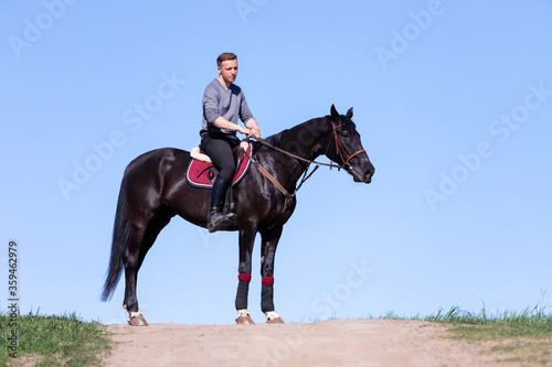 Beautiful man riding a horse on field