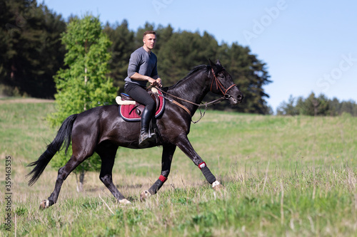 Beautiful man riding a horse on field