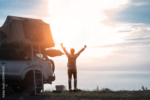 adventurer man in journey travel with off road car and roof tent to enjoy freedom and explorer concept. discover the world living near the power of the nature.