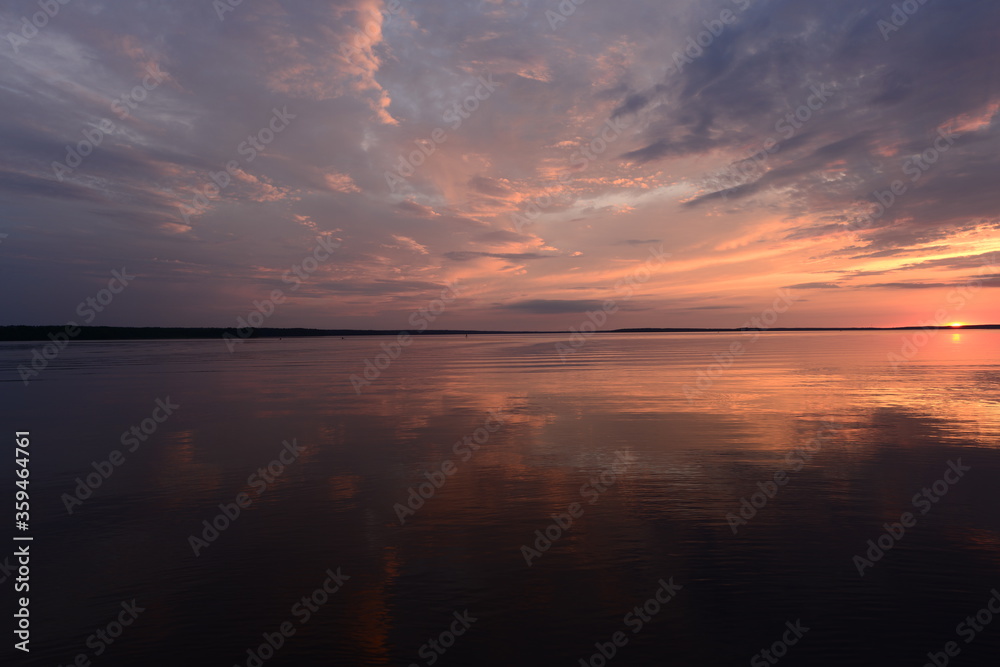 Amazing sunset colors on the lake in the calmness weather in a summer evening