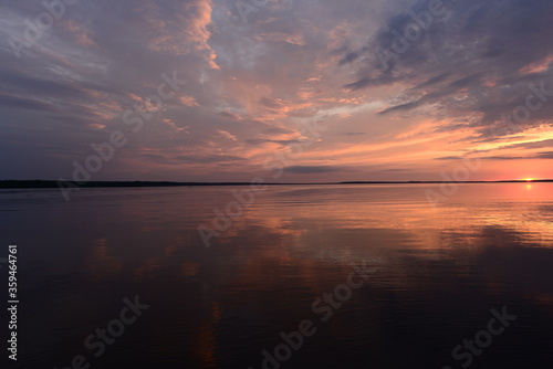 Amazing sunset colors on the lake in the calmness weather in a summer evening