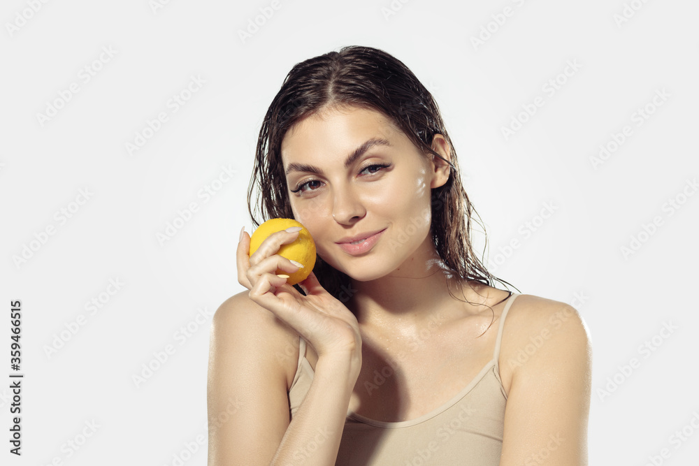 Fresh. Beautiful smiling young woman with lemon near face on white background. Concept of cosmetics, makeup, natural and eco treatment, skin care. Shiny and healthy skin, fashion, healthcare. Fresh. Beautiful smiling young woman with lemon near face on white background. Concept of cosmetics, makeup, natural and eco treatment, skin care. Shiny and healthy skin, fashion, healthcare.