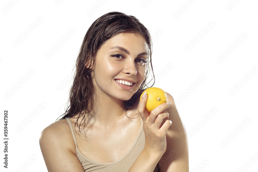 Fresh. Beautiful smiling young woman with lemon near face on white background. Concept of cosmetics, makeup, natural and eco treatment, skin care. Shiny and healthy skin, fashion, healthcare. Fresh. Beautiful smiling young woman with lemon near face on white background. Concept of cosmetics, makeup, natural and eco treatment, skin care. Shiny and healthy skin, fashion, healthcare.