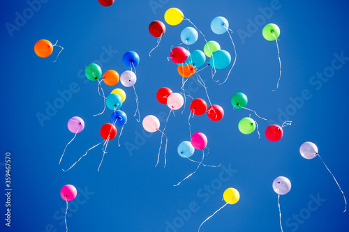 Many multicolored helium balloons fly into the sky