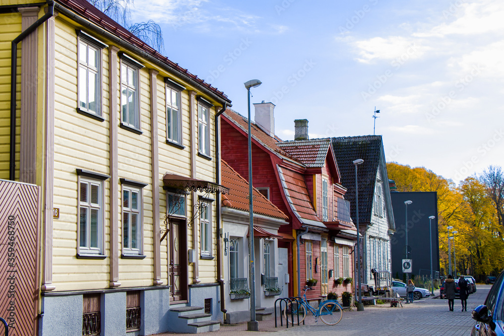 Fototapeta premium Old village wooden house in Parnu, Estonia. Village near baltic sea, resort for summer holidays. People in the street.