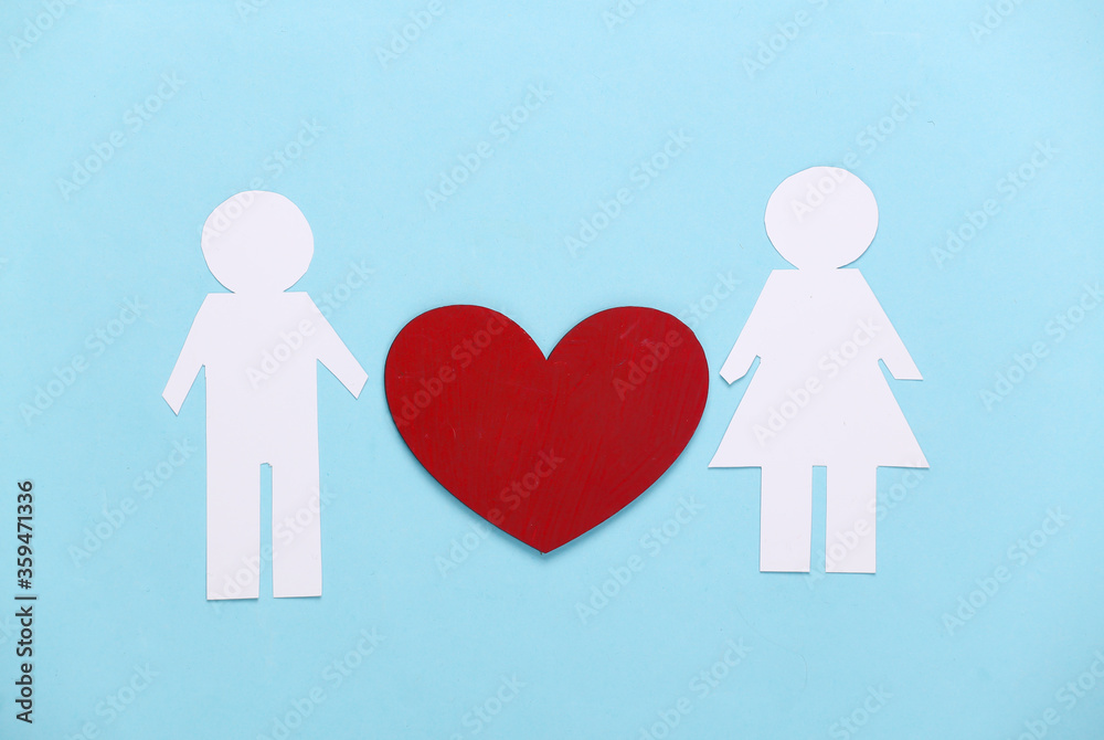 Love concept. Paper man and woman with a red heart on a blue background. Love concept. Paper man and woman with a red heart on a blue background.