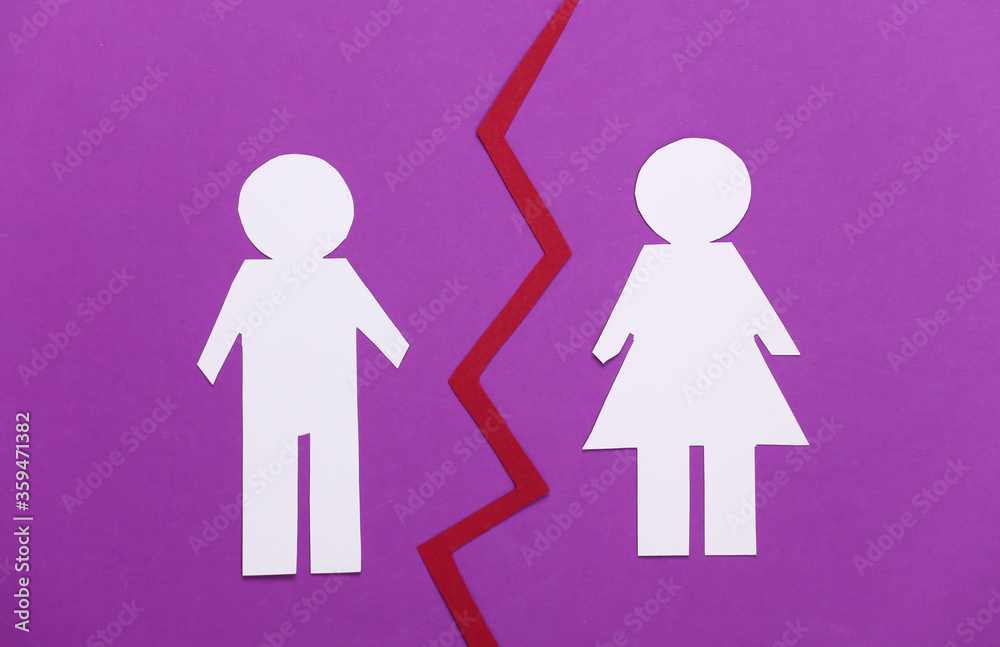 The end of the relationship, divorce. Split paper man and woman on purple background The end of the relationship, divorce. Split paper man and woman on purple background