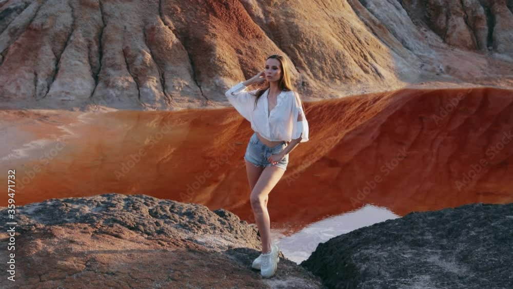 Beautiful woman posing on other-worldly hilly landscape