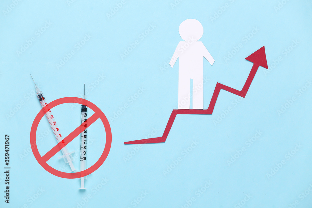 Syringes with a prohibition sign, paper man on growth arrow. Blue background. Symbol of social success. Drug Addiction Recovery Syringes with a prohibition sign, paper man on growth arrow. Blue background. Symbol of social success. Drug Addiction Recovery