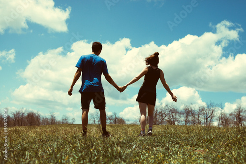 Couple holding hands in an open field