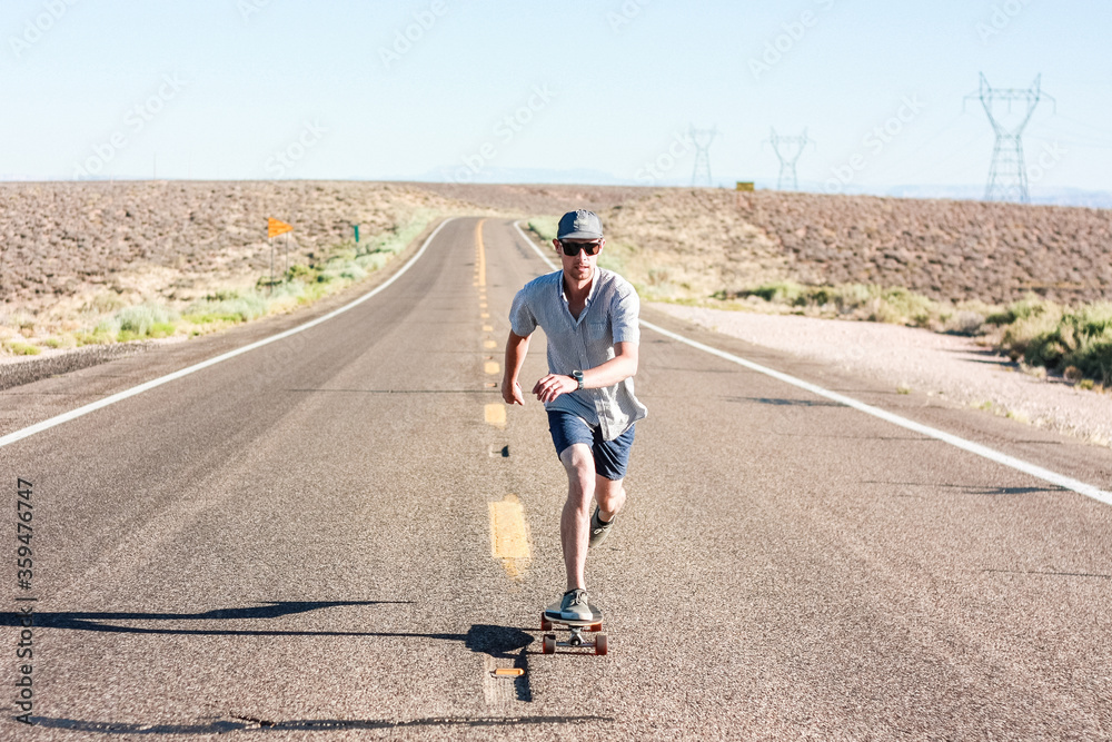 Fototapeta premium Man skateboarding on an open road
