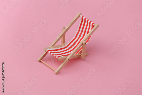 Billede på lærred Red and white striped mini beach deck chair on pink background