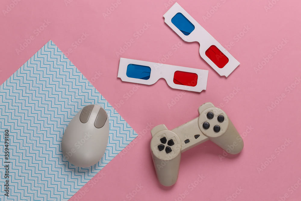 Retro entertainment. Old-fashioned pc mouse, gamepad, anaglyph stereo glasses on blue pink background. Top view. Flat lay Retro entertainment. Old-fashioned pc mouse, gamepad, anaglyph stereo glasses on blue pink background. Top view. Flat lay
