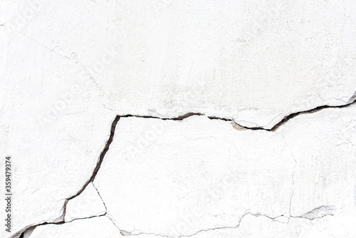 White concrete cracked wall with large crack, background or texture