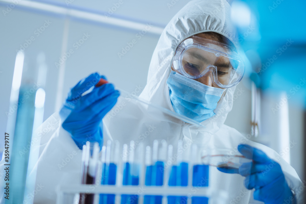 Young man scientist drop and shake biochemical in petri Dish for mixing and looking in laboratory. Doctor and scientist work in laboratory pandemic of corona virus, COVID19 concept Young man scientist drop and shake biochemical in petri Dish for mixing and looking in laboratory. Doctor and scientist work in laboratory pandemic of corona virus, COVID19 concept