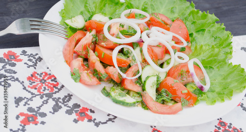Salad with juicy tomatoes, lettuce, cucumber, red onion, arugula, dill and fresh parsley. Homemade food. The symbolic image. The concept of tasty and healthy vegetarian food. Top view and side view. 