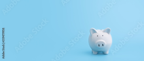 Piggy bank with copy space on blue background,front view