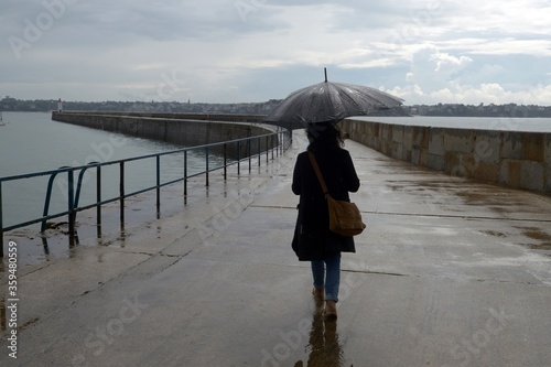 Femme avec un parapluie sur le môle de Saint-Malo en Bretagne