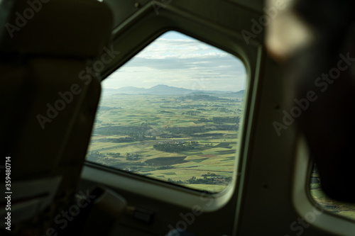 Aerial view on plane window at green fields from Addis Ababa, aircraft aviation business in Africa