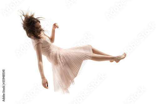 Mid-air beauty cought in moment. Full length shot of attractive young woman hovering in air and keeping eyes closed. Levitating in free falling, lack of gravity. Freedom, emotions, artwork concept. photo