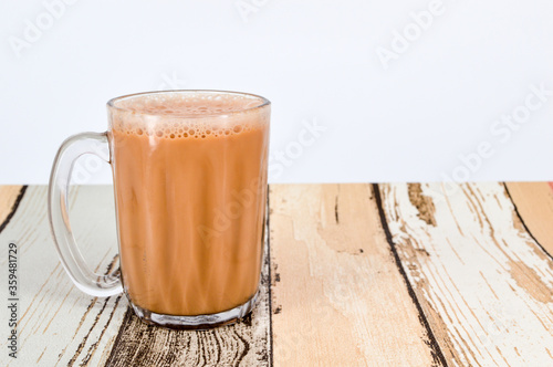 Teh tarik or pulled tea is a famous sweet milk tea in Malaysia. Bubble is floating on the surface of teh tarik.
