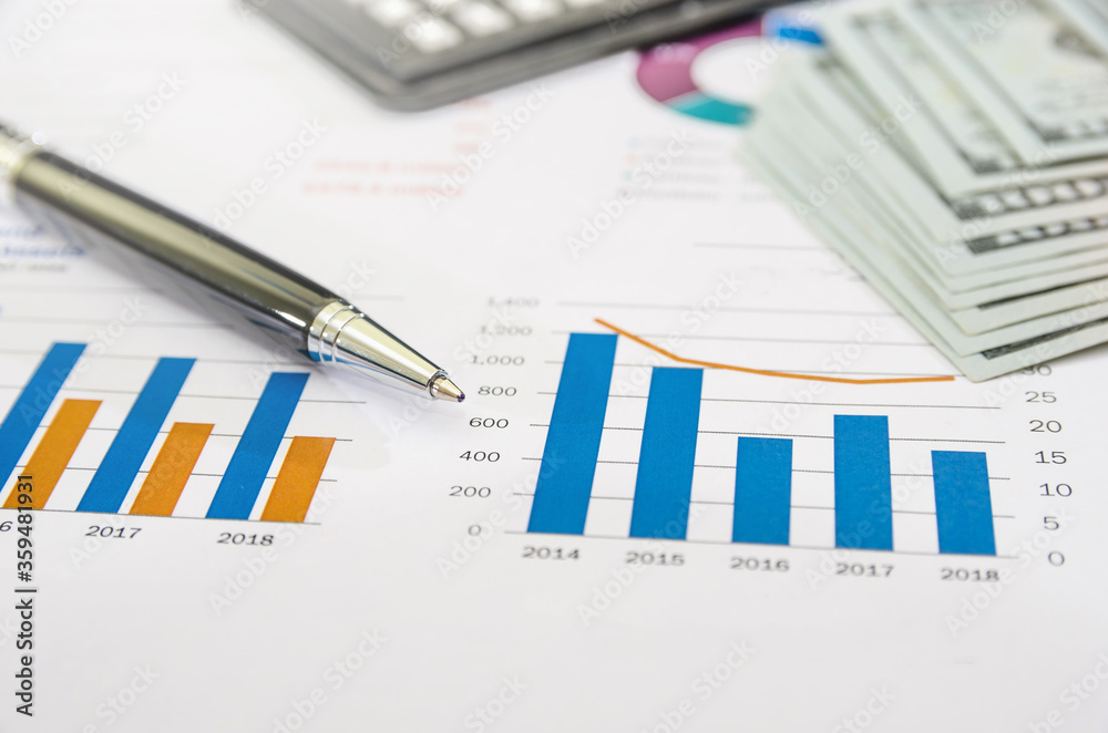 business graph with a calculator, pen and dollars. Income analysis concept. Business reports and diagrams. Close-up. business graph with a calculator, pen and dollars. Income analysis concept. Business reports and diagrams. Close-up.