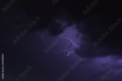 Lightning partly obscured by heavy cloud.
