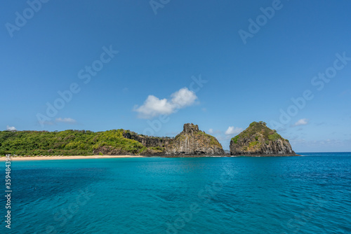 Beautiful background view of Cacimba do Padre beach with Dois Irmaos Hill and turquoise clear water, at Fernando de Noronha, Unesco World Heritage site, Pernambuco, Brazil © MontenegroStock