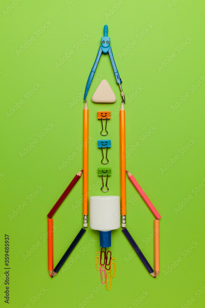 Spaceship (rocket) from stationery on green background. Child imagination, science in elementary school. (preschool) Spaceship (rocket) from stationery on green background. Child imagination, science in elementary school. (preschool)