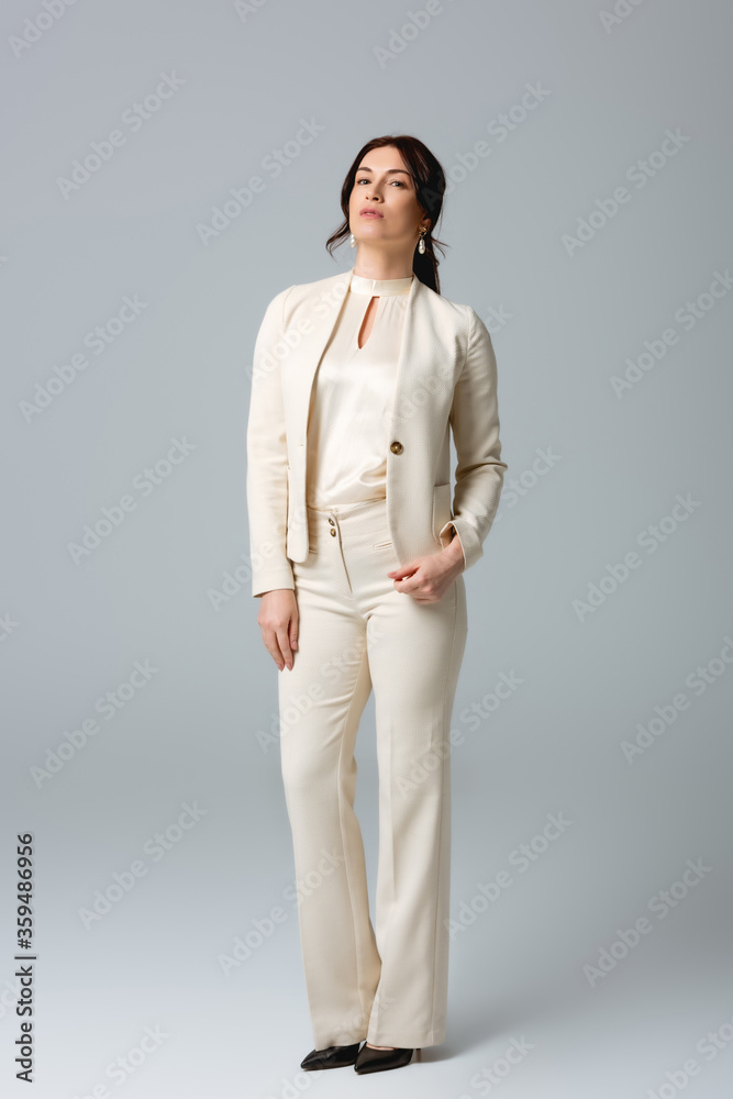 Beautiful businesswoman looking at camera on grey background Beautiful businesswoman looking at camera on grey background