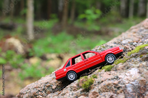 The red toy car on stone in forest