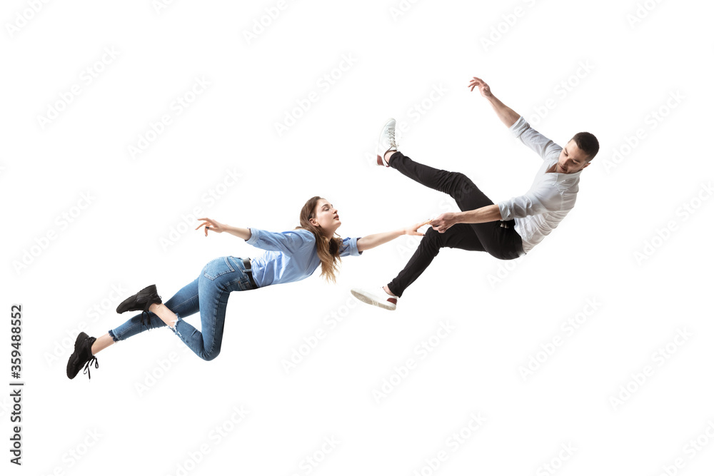 Mid-air beauty cought in moment. Full length shot of attractive young woman  and man hovering in air and keeping eyes closed. Levitating in free  falling, lack of gravity. Freedom, emotions, artwork Stock