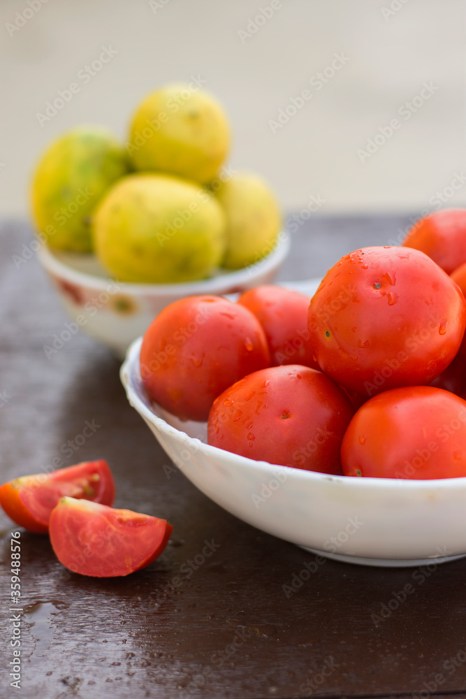 Red organic tomatoes and limes in blurry background Red organic tomatoes and limes in blurry background
