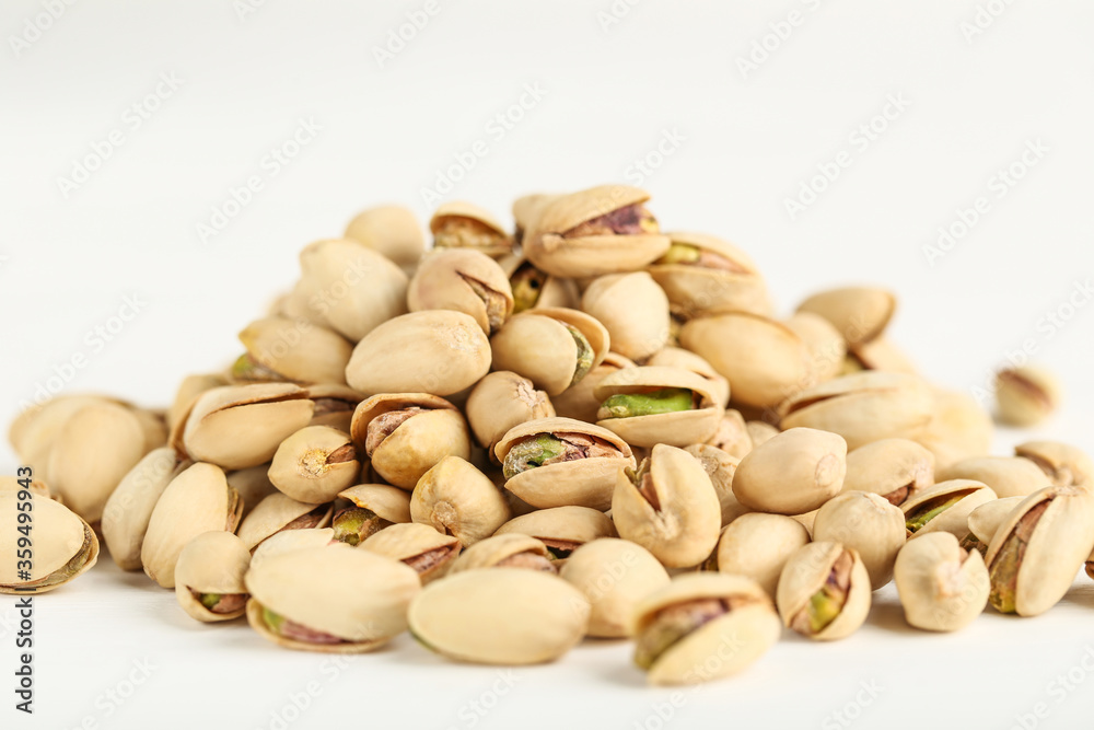 Tasty pistachios on white background