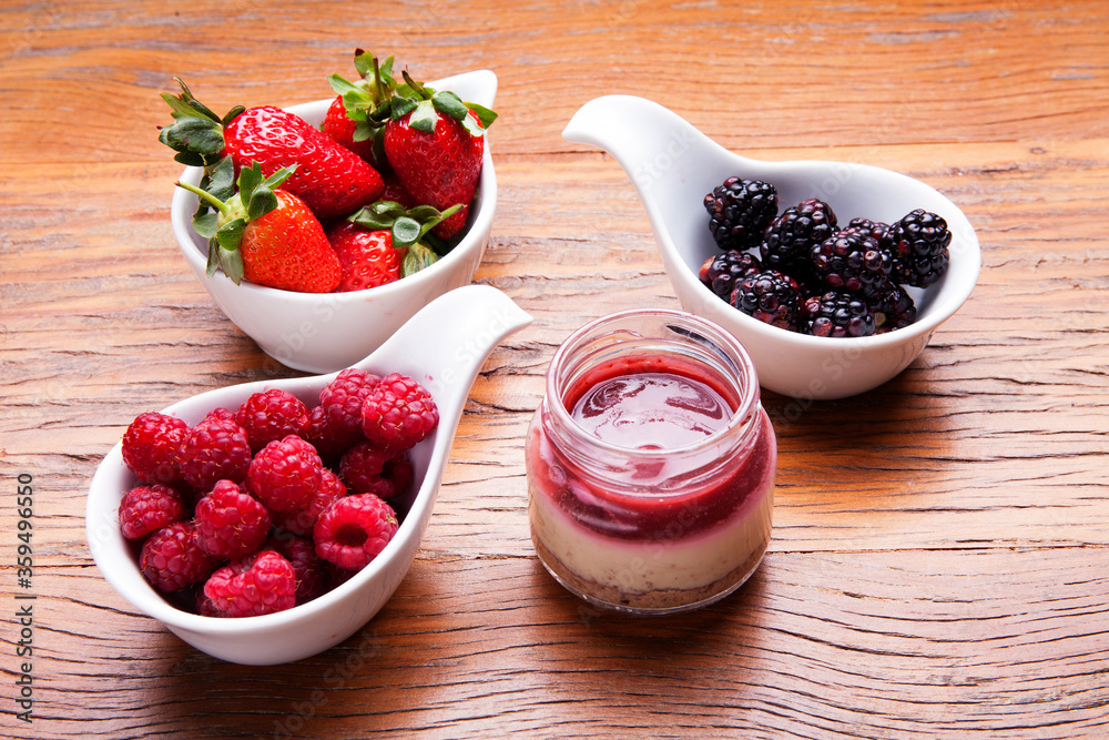 Nutrition concept - Healthy cheese cake in glass jars over wooden background. Healthy food, Diet, Detox, Clean Eating or Vegetarian concept. Delicious dessert option. Nutrition concept - Healthy cheese cake in glass jars over wooden background. Healthy food, Diet, Detox, Clean Eating or Vegetarian concept. Delicious dessert option.