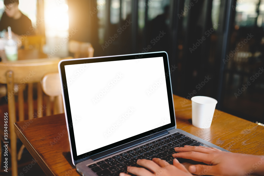 Woman working on laptop with white screen in cafe. Woman working on laptop with white screen in cafe.