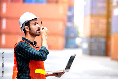 Industrial worker working at cargo freight logistic warehouse for import export, foreman use computer for online internet communication , Import and export business.