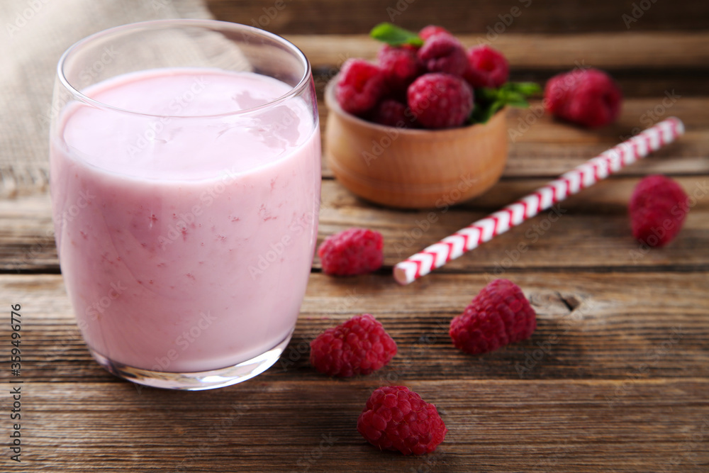 Raspberry smoothie in glass on brown wooden table Raspberry smoothie in glass on brown wooden table
