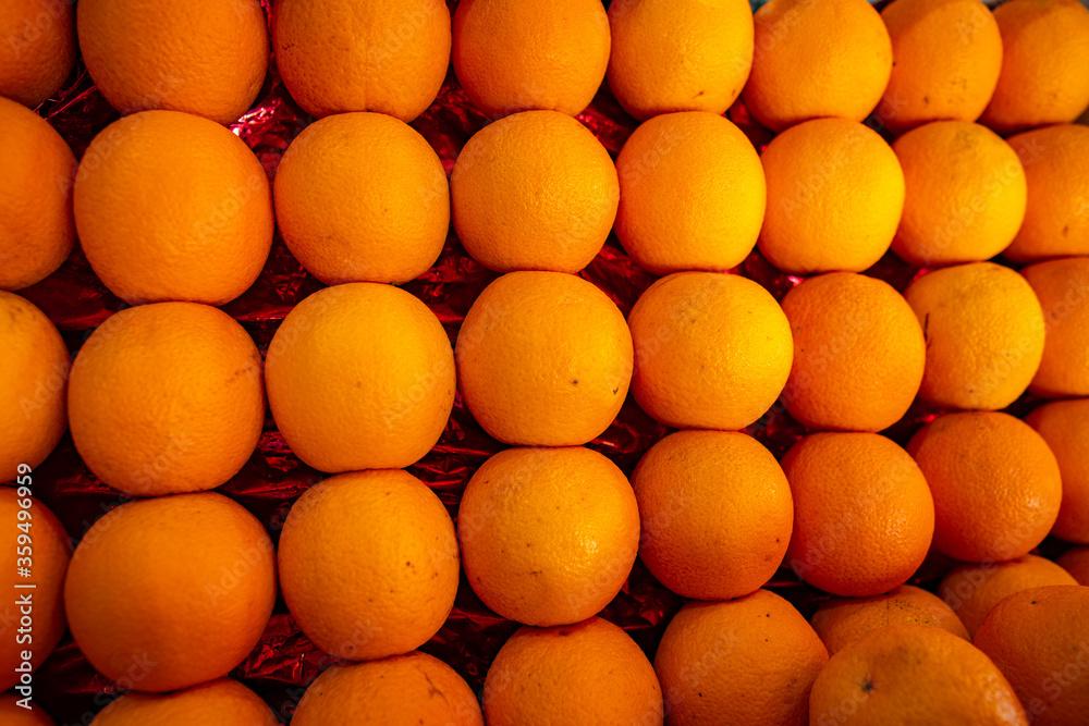 Oranges nicely arranged in market stall for sale. Citrus fruits are very rich source of vitamin c which helps in weight loss and boost immunity.