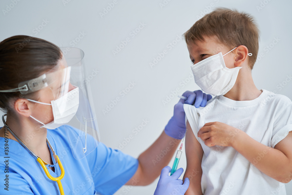 Portrait of adorable little boy being vaccinate at doctor's office Portrait of adorable little boy being vaccinate at doctor's office