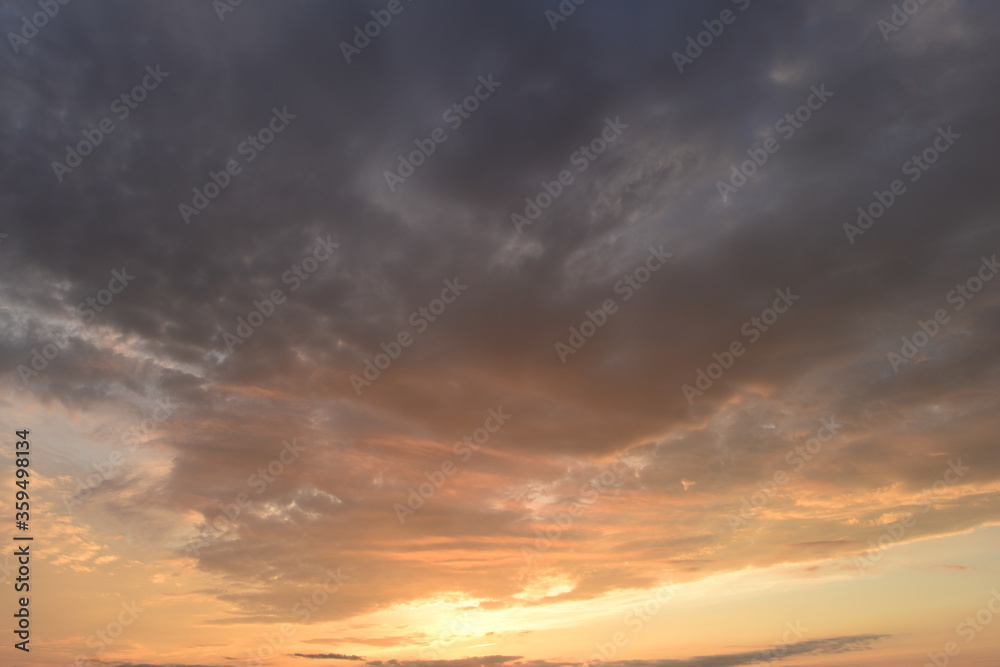 Sunlight sunset glowing in the dark blue cloudy sky Sunlight sunset glowing in the dark blue cloudy sky