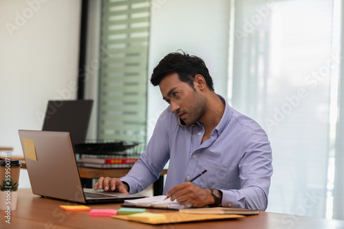 Asian indian business man talking with customer on mobile phone