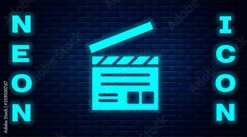Glowing neon Movie clapper icon isolated on brick wall background. Film clapper board. Clapperboard sign. Cinema production or media industry.  Vector Illustration