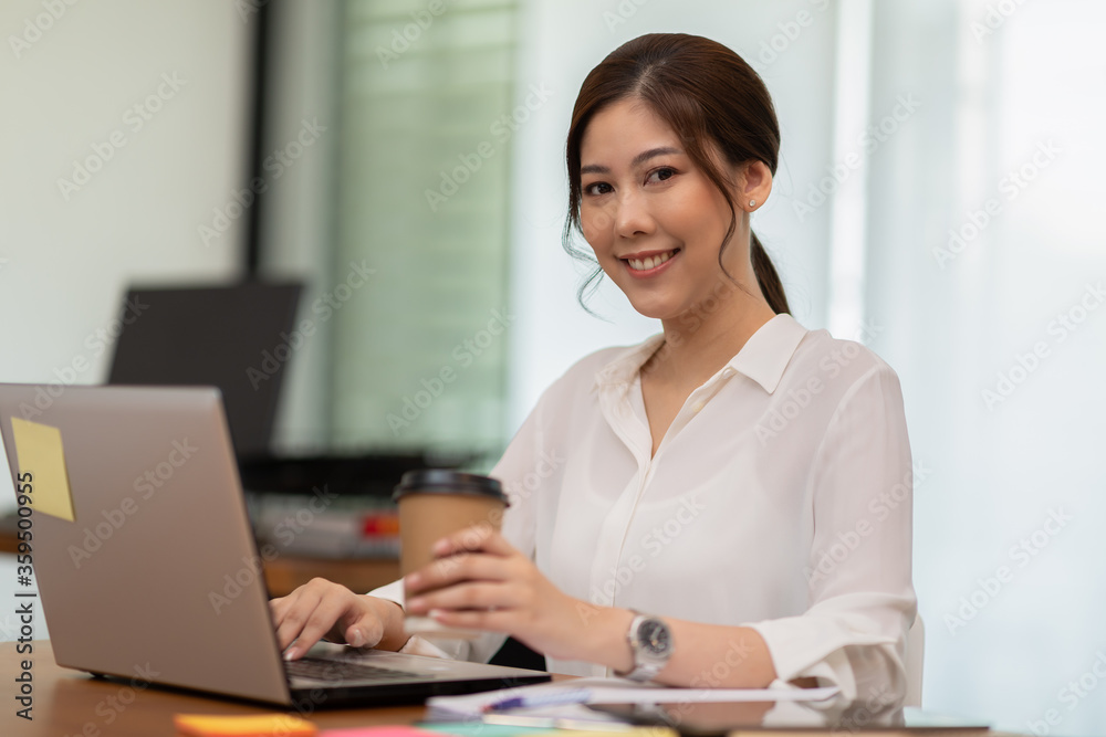 Happy Asian business woman working with laptop and smile Happy Asian business woman working with laptop and smile