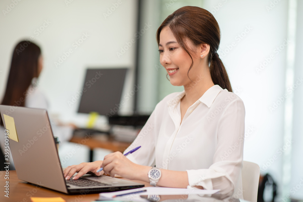 Happy Asian business woman working with laptop and smile Happy Asian business woman working with laptop and smile