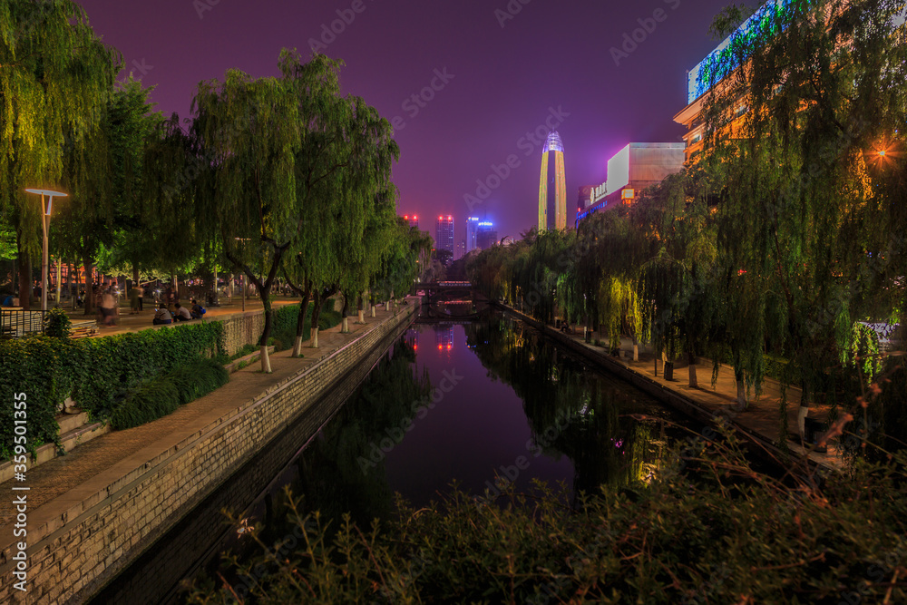 View over water channel of Boatu Spring in Jinan at night in summer