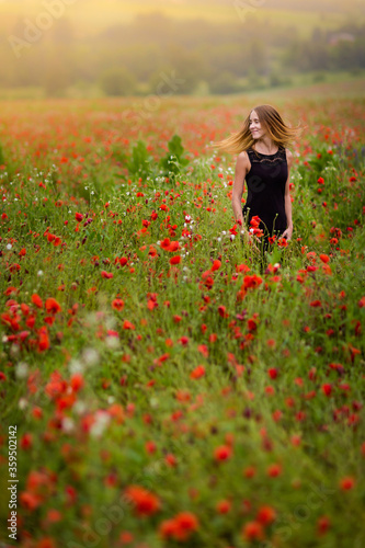 Beautiful smiling woman in red poppy field
