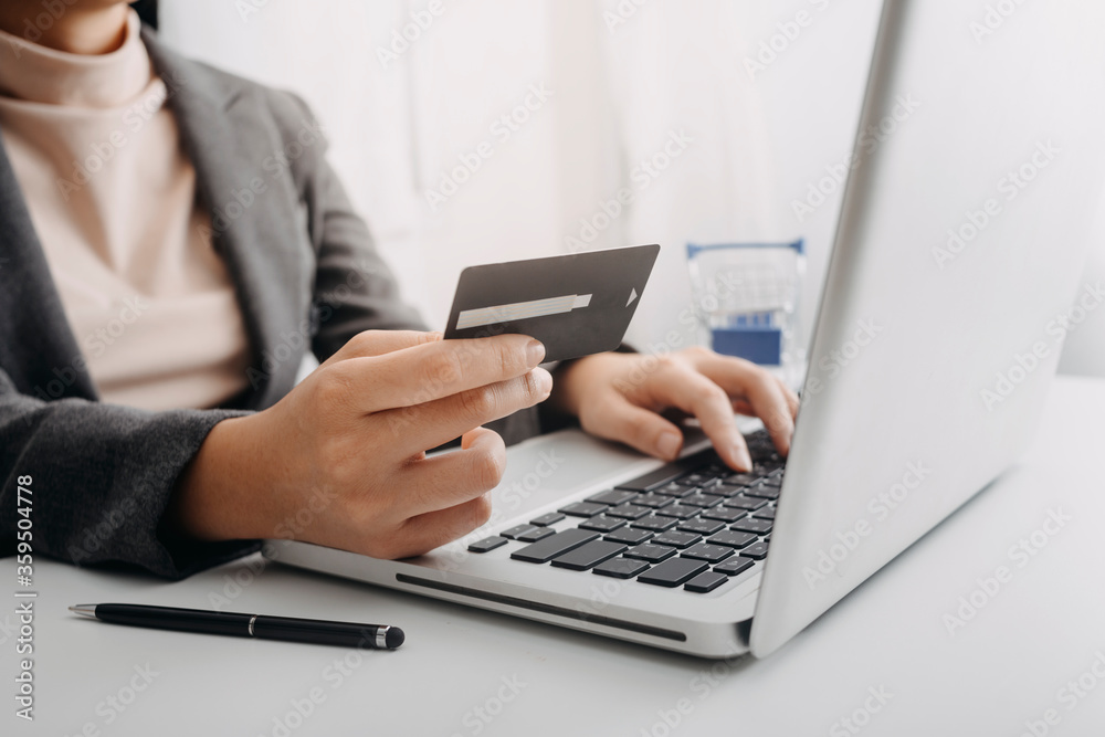 businesswoman hand using smart phone, tablet payments and holding credit card online shopping, omni channel, digital tablet docking keyboard computer at office in sun light businesswoman hand using smart phone, tablet payments and holding credit card online shopping, omni channel, digital tablet docking keyboard computer at office in sun light