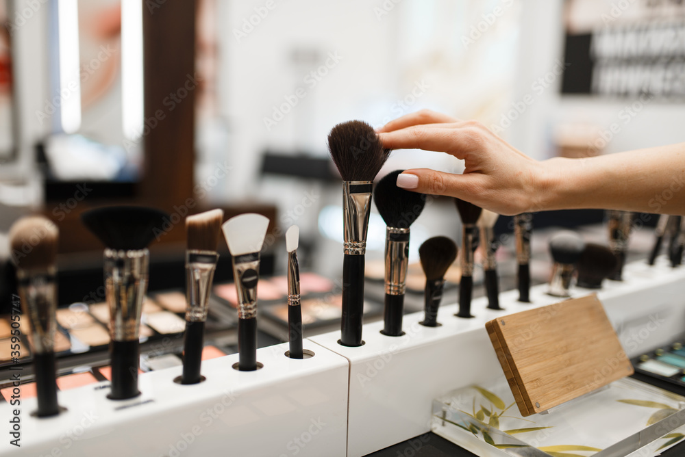 Woman with brush choosing shadows tone in store